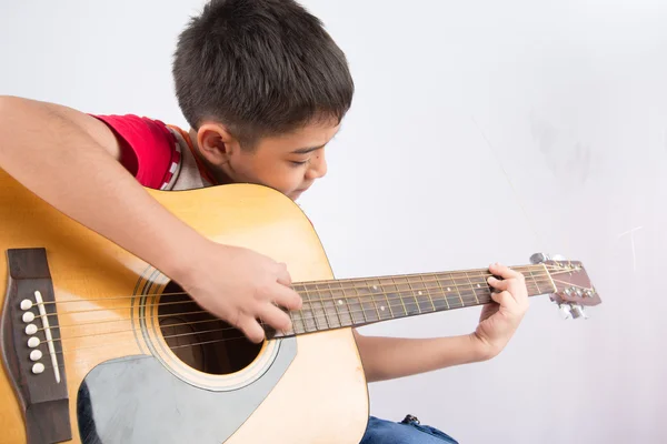 Liten pojke spelar klassisk gitarr på vit bakgrund — Stockfoto