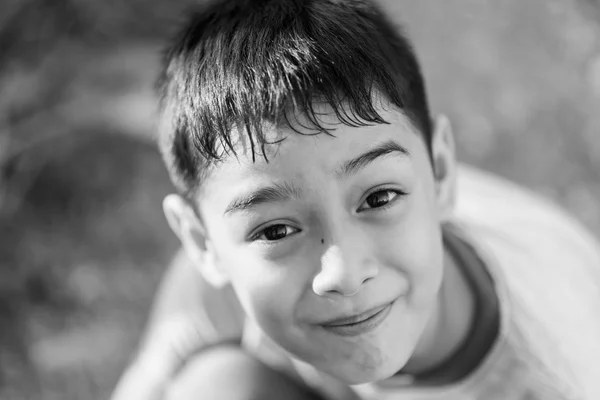 Fechar o rosto feliz do menino ao ar livre no pôr do sol tempo preto e branco — Fotografia de Stock