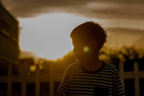 Nära håll happe ansikte av pojke utomhus i solnedgången tid — Stockfoto