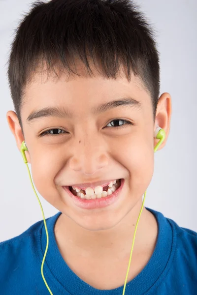Niño sonriendo con auriculares escucha la música —  Fotos de Stock