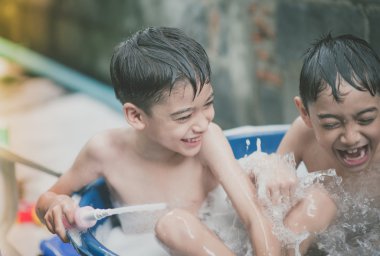 Küçük çocuk su sıçrama arka bahçesinde açık hava etkinlikleri yazın oynamaya sıcak zaman 