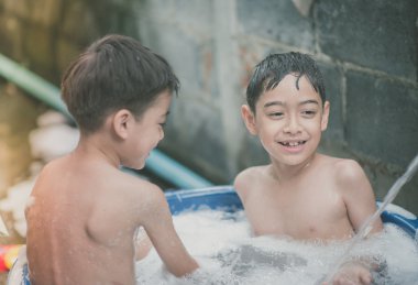 Küçük çocuk su sıçrama arka bahçesinde açık hava etkinlikleri yazın oynamaya sıcak zaman 