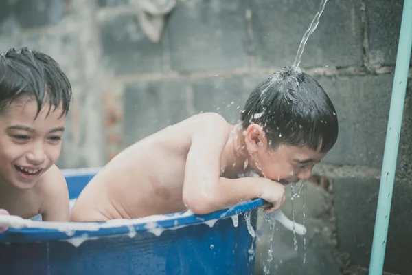 Niño jugando salpicadura de agua en el patio trasero actividades al aire libre verano tiempo cálido —  Fotos de Stock