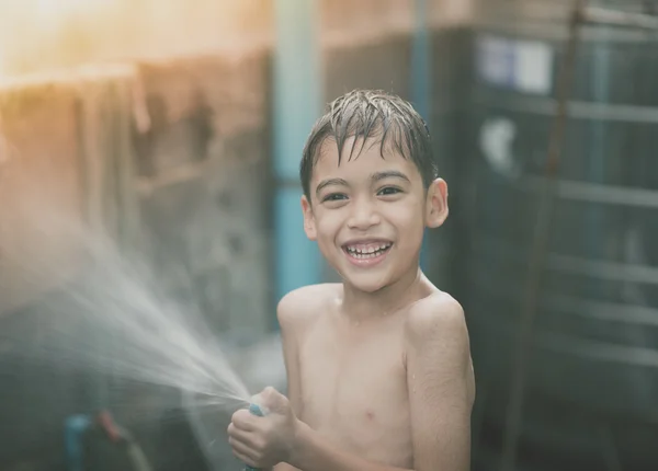 Menino jogando água respingo no quintal atividades ao ar livre verão tempo quente — Fotografia de Stock