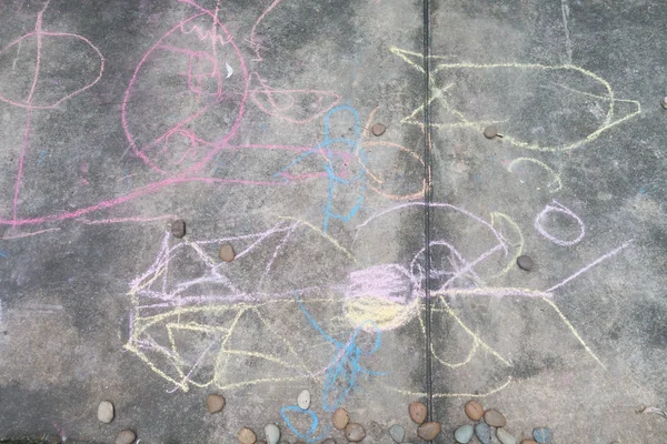 Kleiner Junge zeichnet und färbt mit Kreide auf dem Boden — Stockfoto
