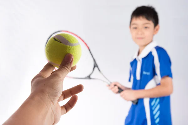 Menino jogando raquete de tênis e bola de tênis na mão — Fotografia de Stock