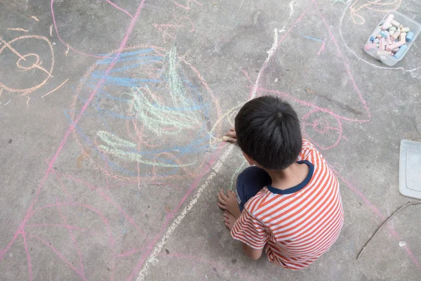 Ragazzino disegno e colorazione da gesso a terra — Foto Stock