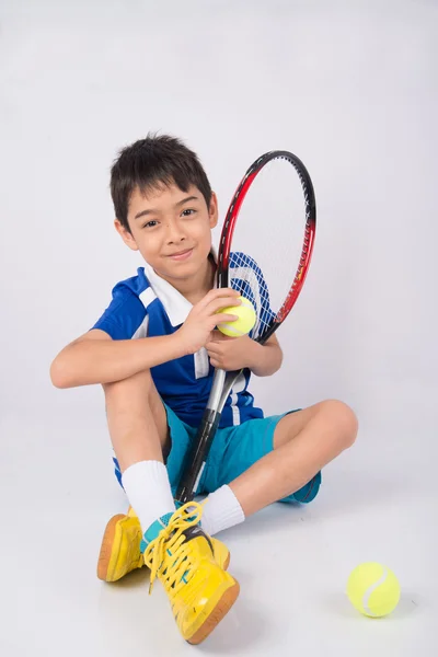 Niño jugando raqueta de tenis y pelota de tenis en la mano — Foto de Stock