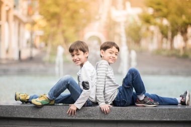 Çeşmede birlikte oturan küçük kardeş çocuk