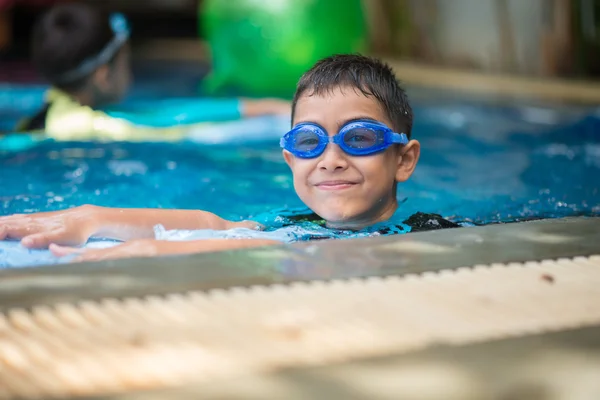 Meng beetje Aziatische Arabische jongen zwemmen bij zwembad in het hotel outdoor activiteit — Stockfoto