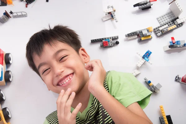 Little boy laying down with plastic block around — Stock Photo, Image