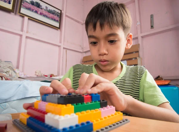 Μικρό αγόρι παίζει πλαστικό μπλοκ κτίριο εκπαίδευσης εσωτερική δραστηριότητα — Φωτογραφία Αρχείου