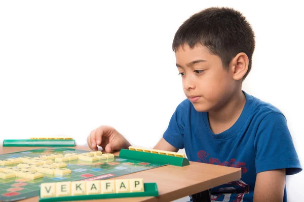 Kleine jongen spelen puzzel kruiswoordraadsel binnen activiteit taalonderwijs — Stockfoto