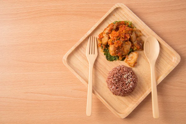 Arroz integral con pasta picante revuelto frito con pescado en plato de madera — Foto de Stock