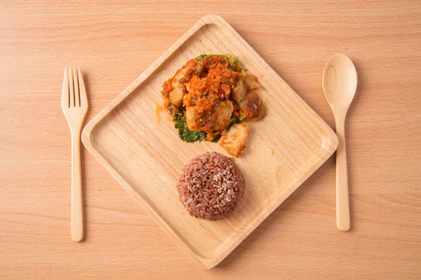 Arroz integral con pasta picante revuelto frito con pescado en plato de madera — Foto de Stock