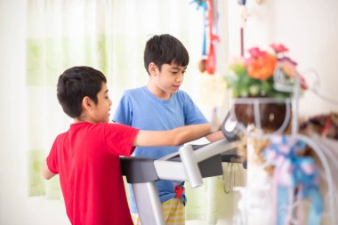 Genç çocuk egzersiz için koşu bandında koşuyor.