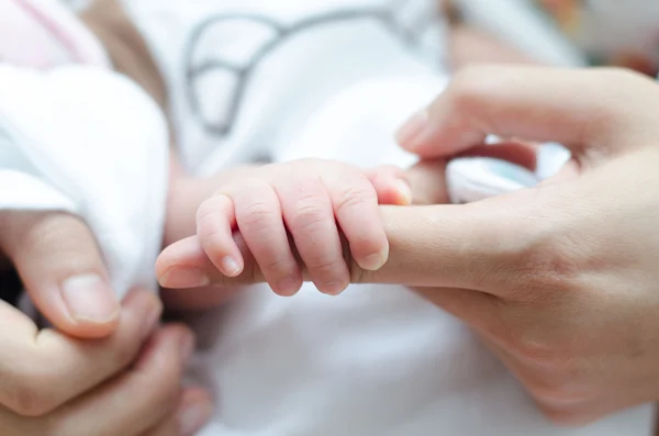 Ručky malé miminko drží matka prst — Stock fotografie