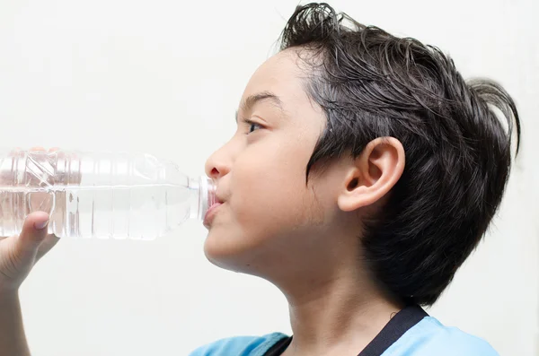 Kleine jongen drinkt water uit een fles na uitoefening — Stockfoto