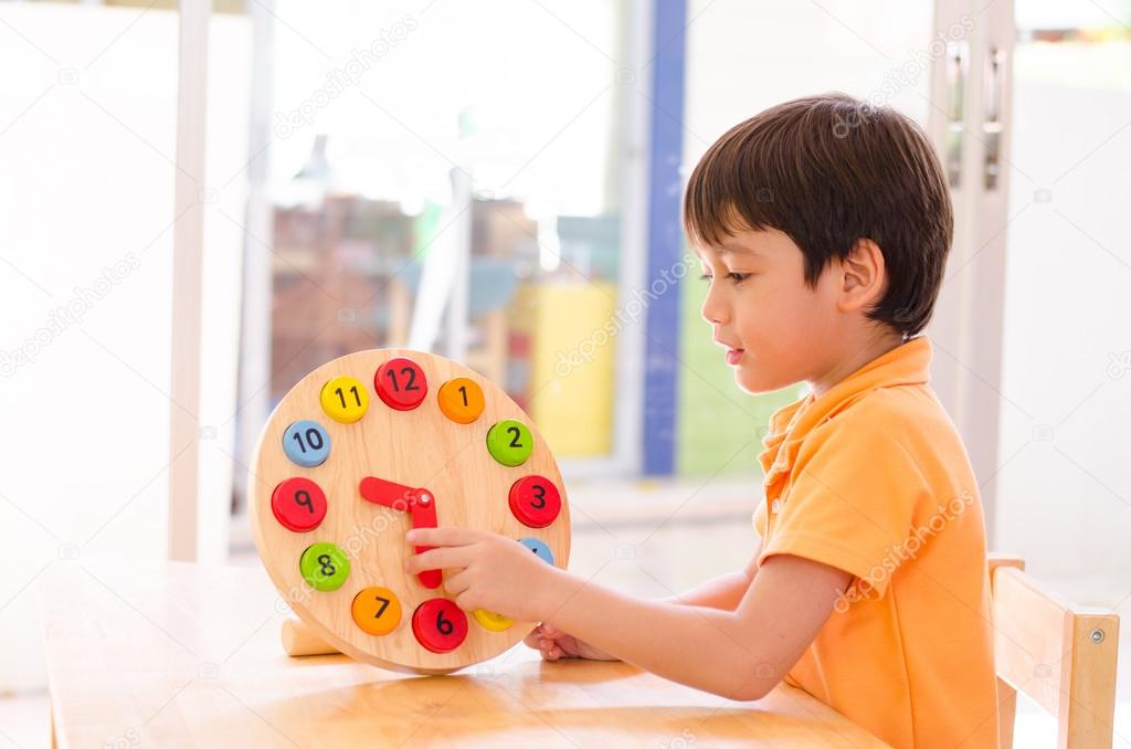 Little boy learning time with clock toy of montessori educationa