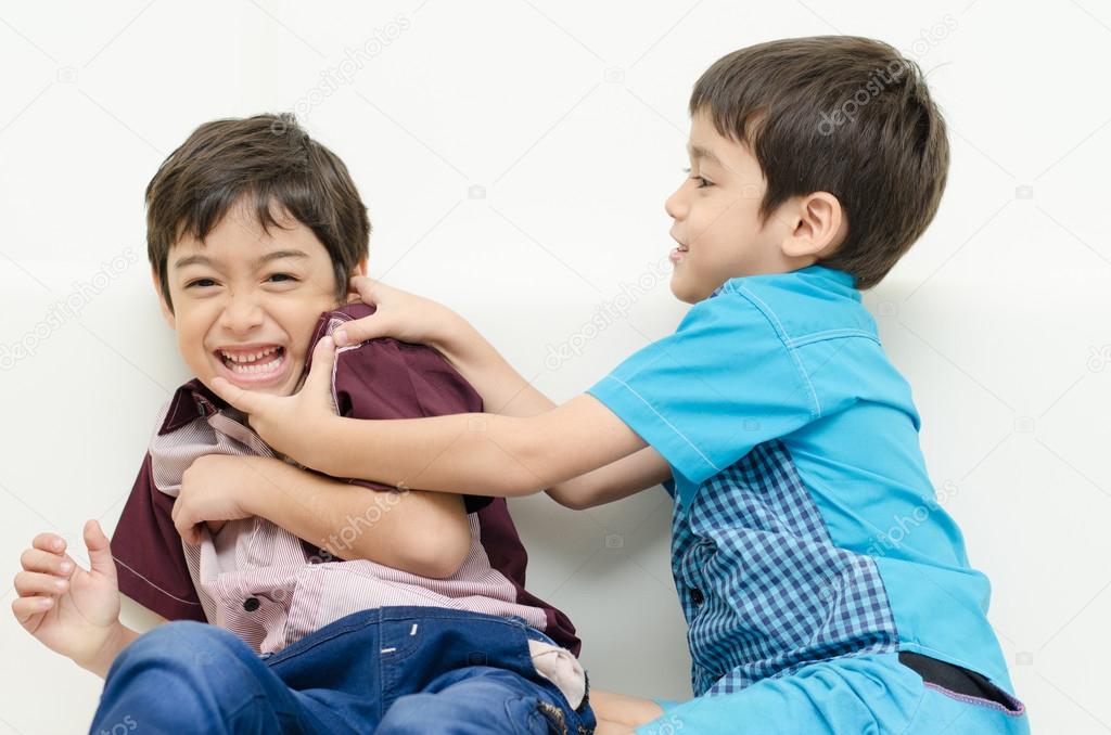Little sibling boy fighting on sofa