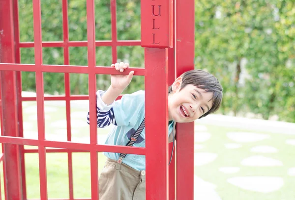 Маленький хлопчик посміхається з дверей — стокове фото
