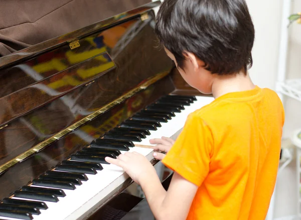 Liten pojke spela piano — Stockfoto