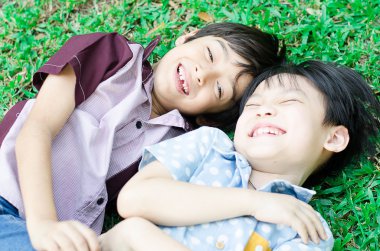 Küçük erkek arkadaş birlikte parkta gülmek