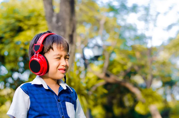 Niño escuchando con la cabeza en el parque — Foto de Stock