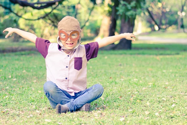 Petit garçon jouer comme pilote dans le style vintage du parc — Photo