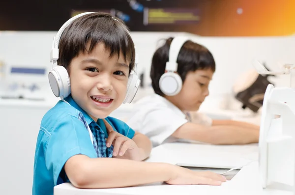 Liten pojke med headsetet i klassrummet — Stockfoto