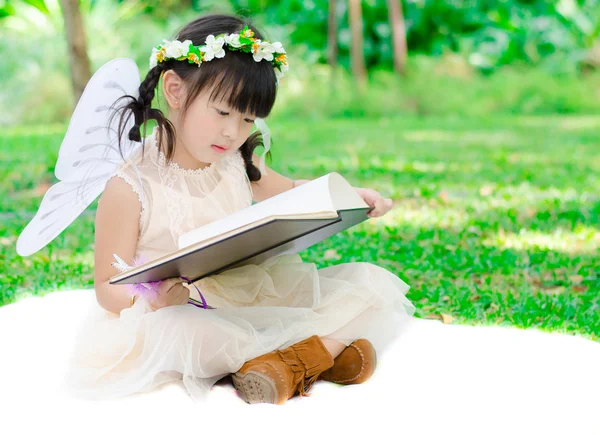 Κοριτσάκι, διαβάζοντας ένα βιβλίο στο πάρκο — Φωτογραφία Αρχείου