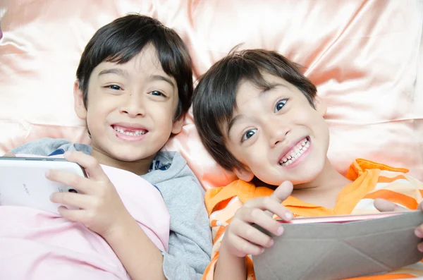 Little sibling boy playing game in the bed — Stock Photo, Image