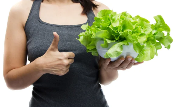 Женщина держит миску с зелеными органическими овощами на белой ба — стоковое фото