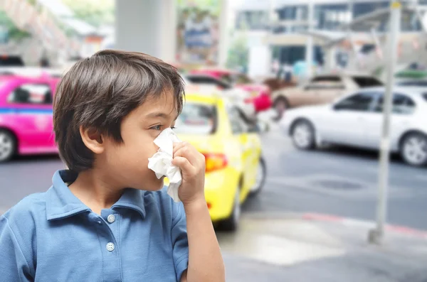 Menino espirrando causa alérgica na estrada — Fotografia de Stock