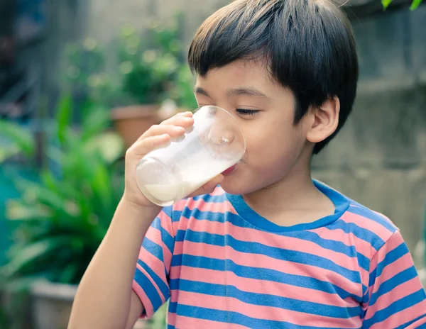 Piccolo ragazzo che beve latte nel parco in stile vintage — Foto Stock