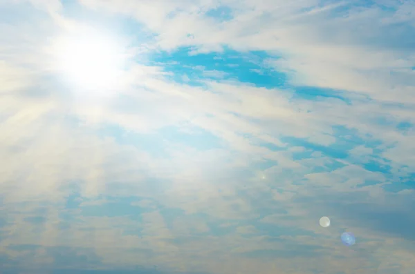 Голубое небо с солнечным светом, вспышками и облаками — стоковое фото