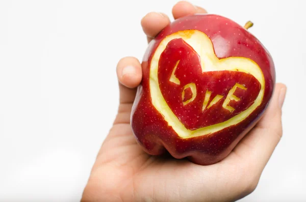 Jabłko, serce, miłość w ręce kobieta na białym tle — Zdjęcie stockowe