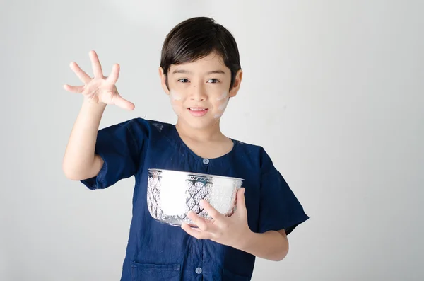 Thai boy opspattend water met behulp van hand uit kom — Stockfoto
