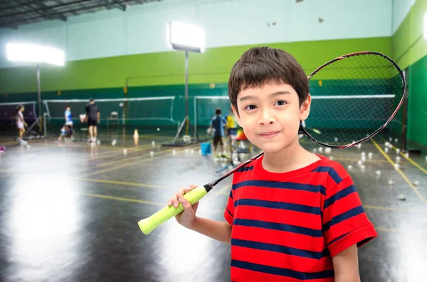 Kleiner Junge mit Badmintonschläger im Training in der Turnhalle — Stockfoto