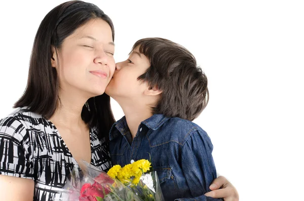 Little boy kissing his mother with flower on white background — Stock Photo, Image