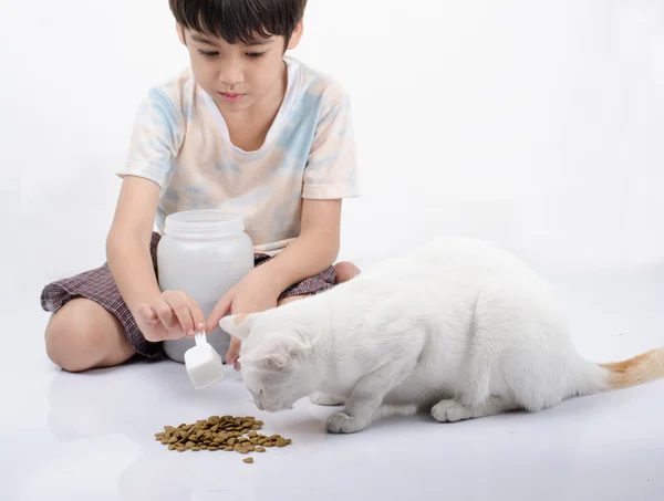 Little boy giving food for cat — Stock Photo, Image