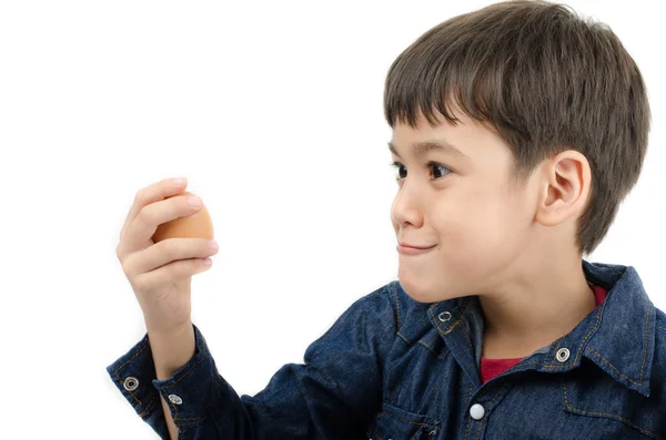 Niño pequeño sosteniendo huevo en la mano sano sobre fondo blanco — Foto de Stock