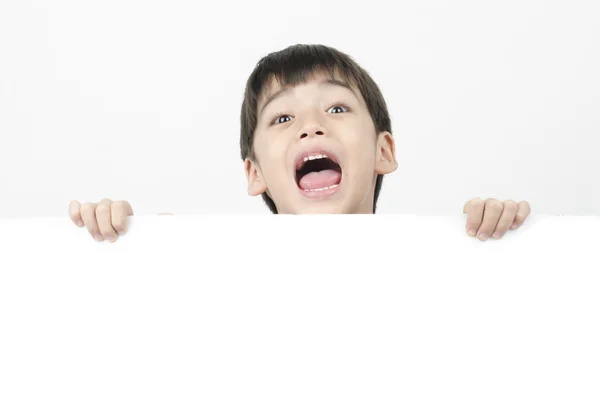 Liten pojke med överraskning ansikte bakom whiteboard-tavlan — Stockfoto