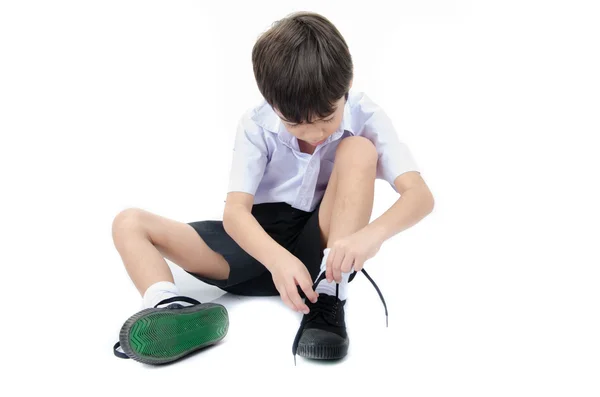 Menino amarrar sapatos prontos para a escola no fundo branco — Fotografia de Stock