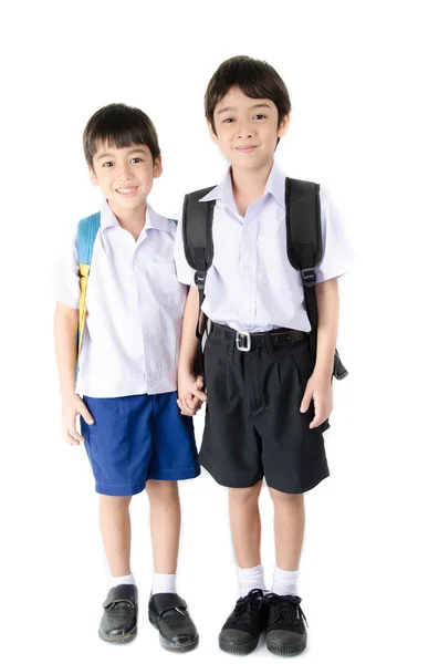 Malý chlapec sourozenec studenta v uniformě na bílém pozadí — Stock fotografie