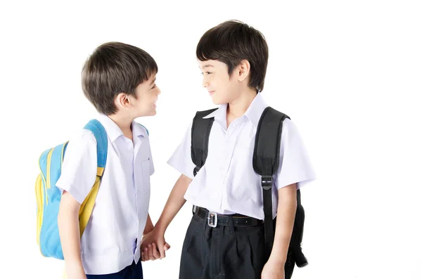 Pequeño estudiante hermano niño en uniforme sobre fondo blanco — Foto de Stock