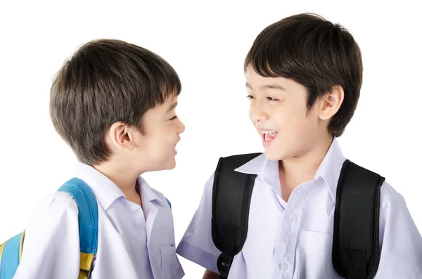 Pequeño estudiante hermano niño en uniforme sobre fondo blanco — Foto de Stock