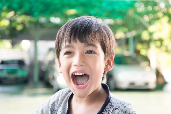 Маленький мальчик улыбается портрет со счастливым лицом на белом фоне — стоковое фото