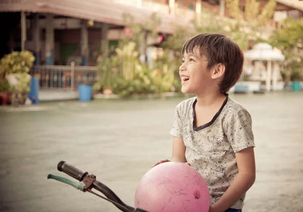 Băiețelul care stă pe bicicletă zâmbind cu fața fericită la locul de joacă — Fotografie, imagine de stoc