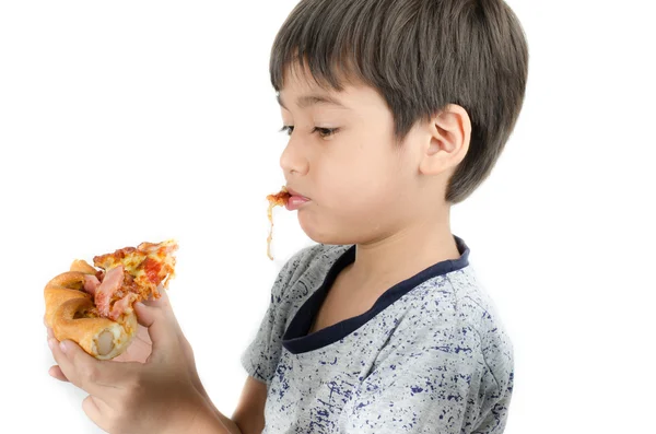 Маленький мальчик ест пиццу на белом фоне — стоковое фото